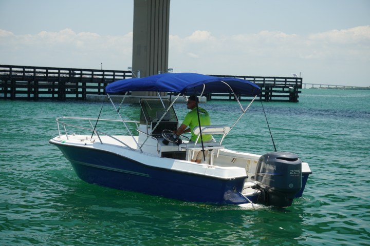 Man driving a 22 foot stratos center console boat rental in St Pete Florida