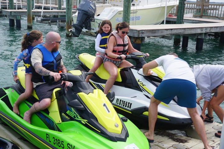 Parents and kids riding on two jet skis in St Pete FL