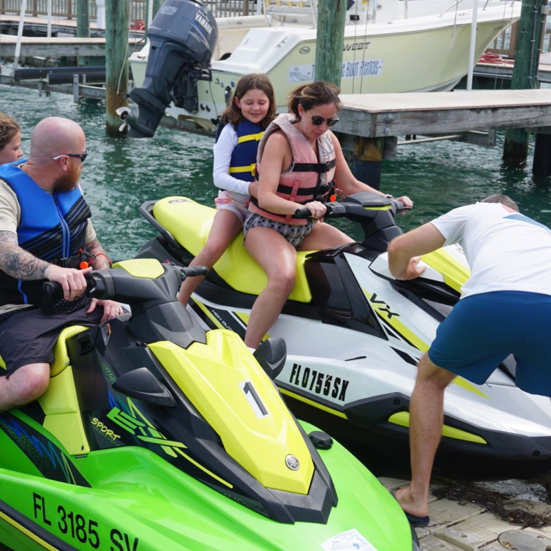 Parents and kids riding on two jet skis in St Pete FL