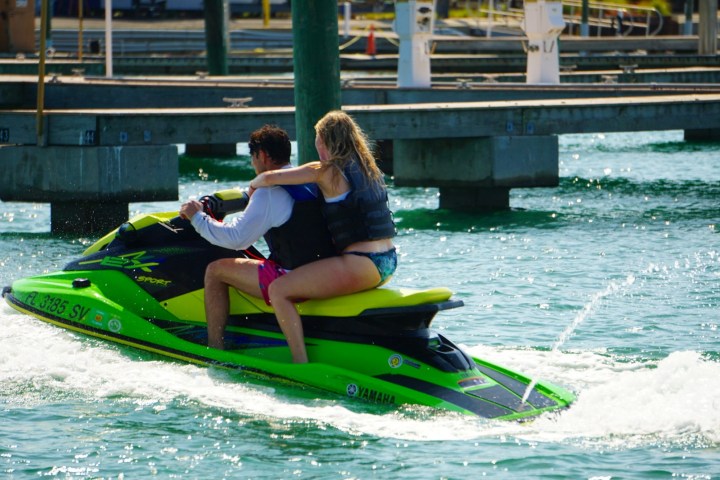 a couple in life jackets riding a wave runner jet ski in St Pete