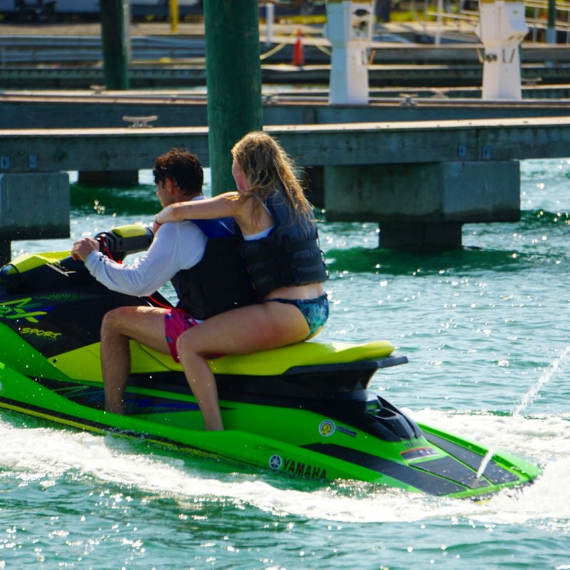 a couple in life jackets riding a wave runner jet ski in St Pete