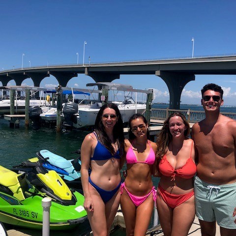 Four adults in bathing suits about to drive single jet ski rentals in St Pete Florida
